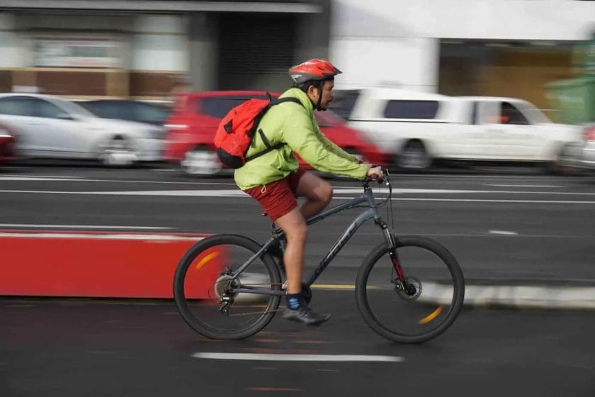 Cycling Knee Pain Explained - A man cycling his bicycle on the street.